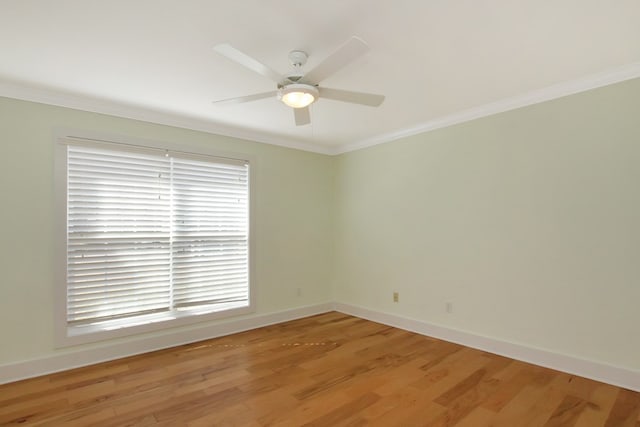 unfurnished room with light wood-style floors, ceiling fan, baseboards, and ornamental molding