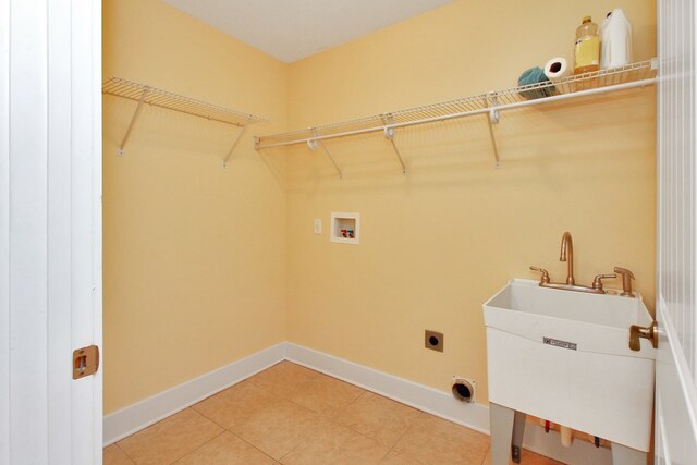 washroom with light tile patterned flooring, hookup for a washing machine, hookup for an electric dryer, laundry area, and baseboards