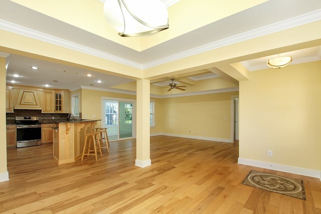 kitchen featuring a breakfast bar, dark countertops, electric range, backsplash, and open floor plan