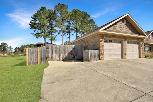 view of home's exterior with a garage, driveway, fence, and a yard