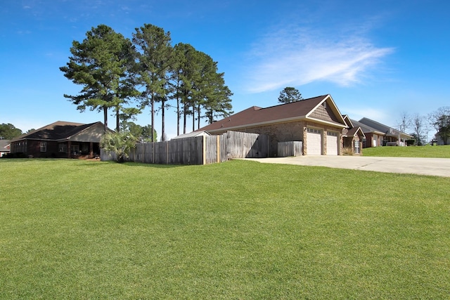 view of side of home featuring a garage, fence, concrete driveway, and a yard