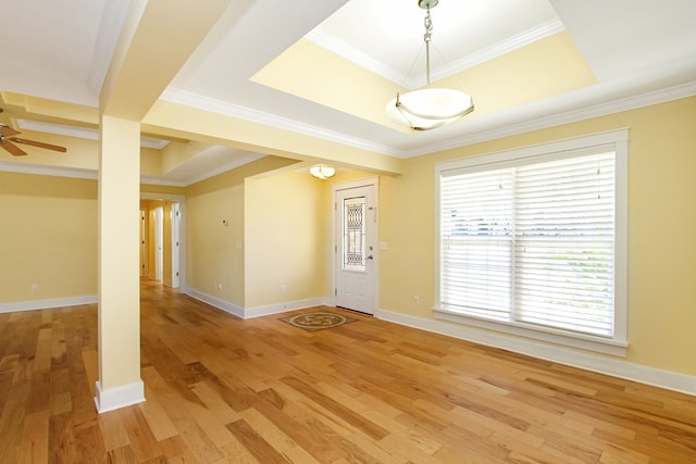 entrance foyer featuring light wood-type flooring, a raised ceiling, and baseboards