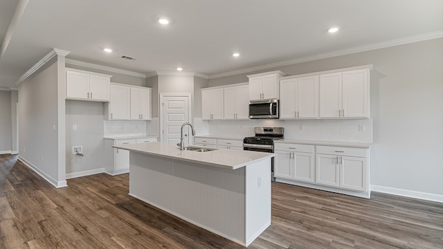 kitchen with appliances with stainless steel finishes, dark wood-type flooring, a sink, and an island with sink