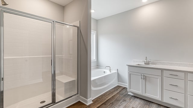 308 Heritage Way, Headland, AL 36345 - full bath featuring a garden tub, wood finished floors, vanity, baseboards, and a shower stall