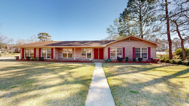 ranch-style home featuring a front yard and brick siding