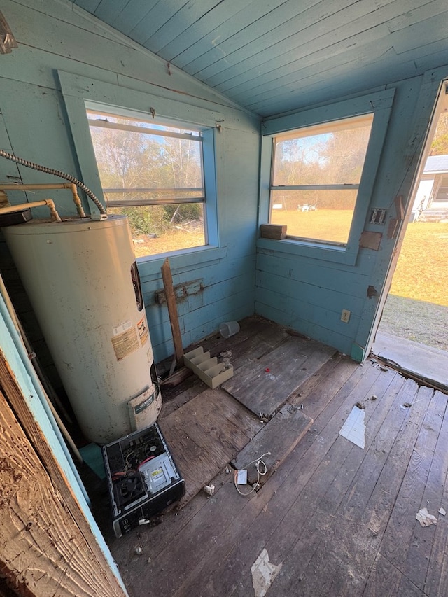 interior space featuring a wealth of natural light, wood-type flooring, water heater, and lofted ceiling