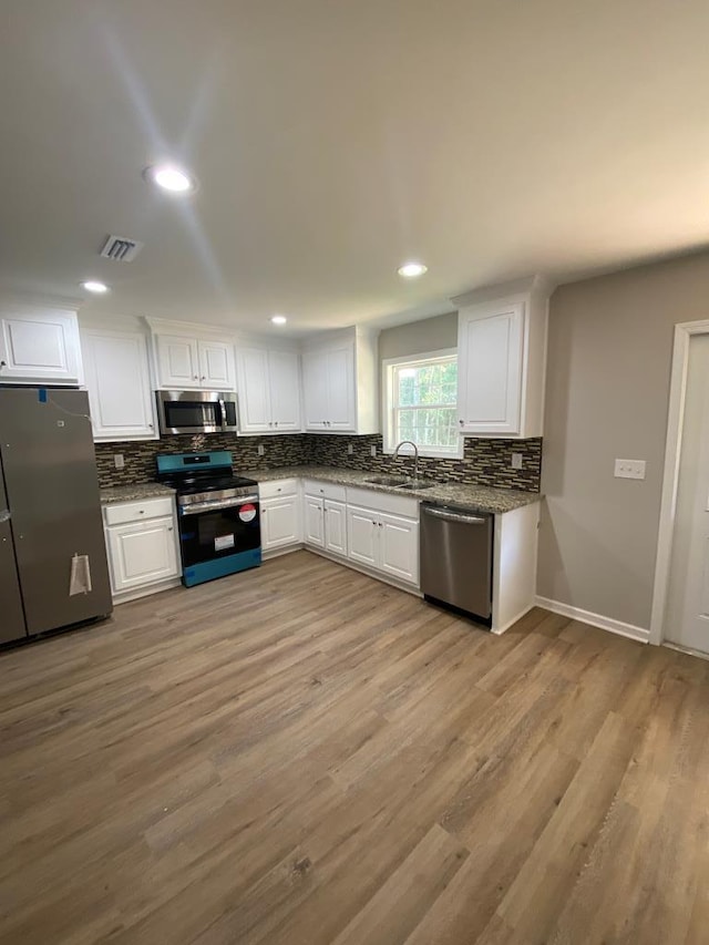 kitchen featuring white cabinets, light wood-type flooring, sink, and appliances with stainless steel finishes