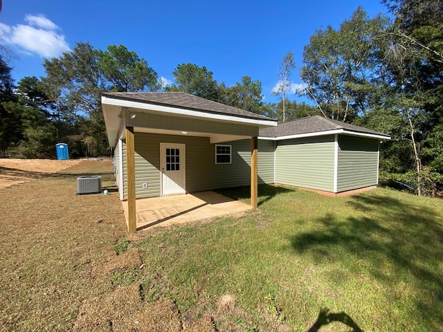 rear view of house featuring central AC unit, a patio, and a lawn