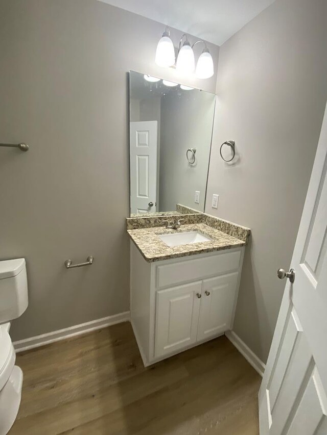 bathroom featuring hardwood / wood-style floors, vanity, and toilet