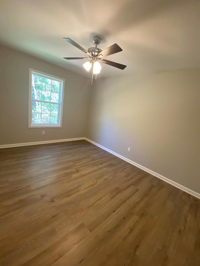 empty room featuring ceiling fan and dark wood-type flooring