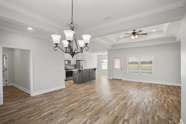 interior space featuring hardwood / wood-style floors, crown molding, ceiling fan with notable chandelier, and a raised ceiling