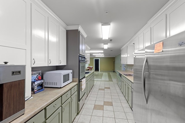 2054 John D Odom Rd, Dothan, AL 36303 - kitchen with freestanding refrigerator, white microwave, light countertops, light tile patterned floors, and white cabinetry