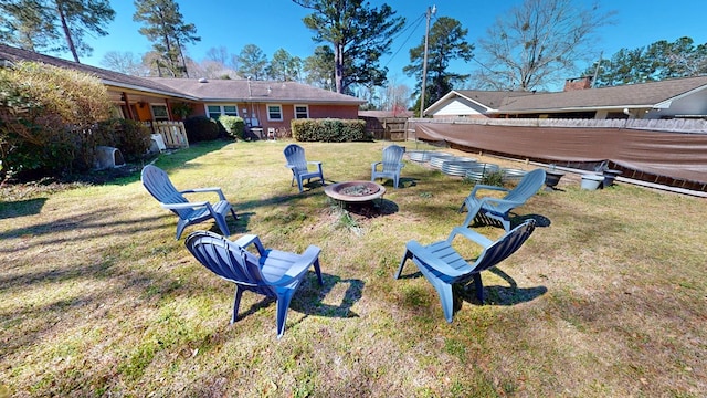 view of yard featuring an outdoor fire pit and fence