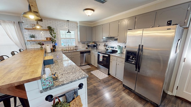 kitchen featuring ornamental molding, a peninsula, appliances with stainless steel finishes, and under cabinet range hood