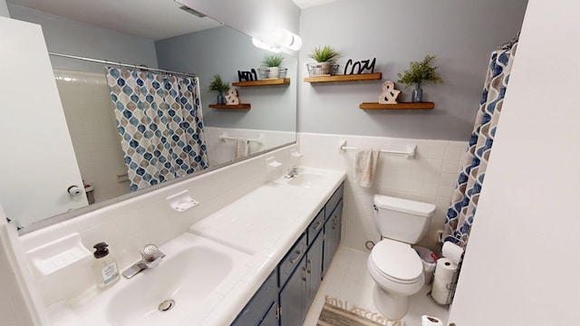 bathroom featuring visible vents, wainscoting, toilet, a sink, and tile walls