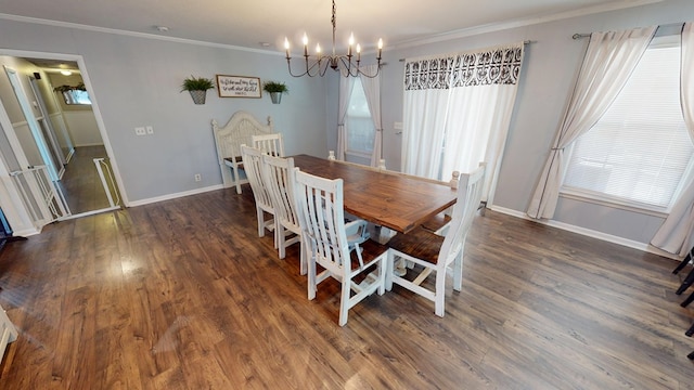 dining area featuring baseboards, crown molding, and wood finished floors