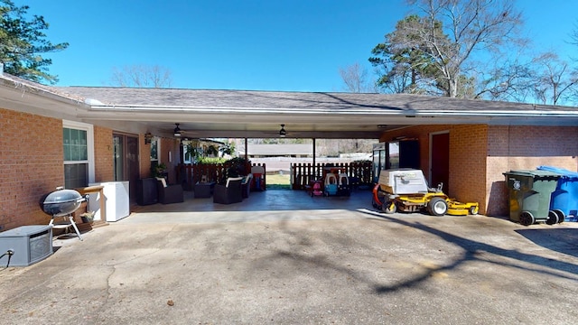 view of parking with driveway, a ceiling fan, and a carport