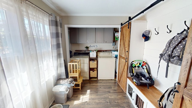 mudroom with dark wood-style floors, a barn door, crown molding, and washer and dryer