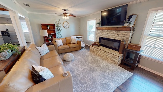 living area with a fireplace, crown molding, baseboards, and wood finished floors