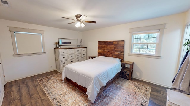 bedroom with a ceiling fan, baseboards, visible vents, and wood finished floors