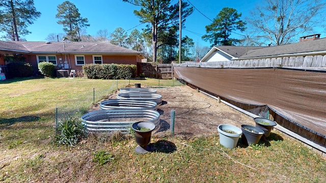 view of yard with a fenced backyard and a vegetable garden