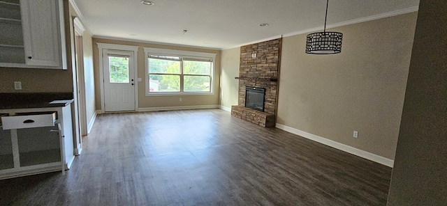 unfurnished living room featuring dark hardwood / wood-style flooring, a fireplace, and ornamental molding