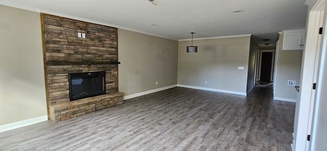 unfurnished living room featuring hardwood / wood-style flooring, crown molding, and a stone fireplace