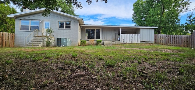 view of front facade with central AC unit and a front yard