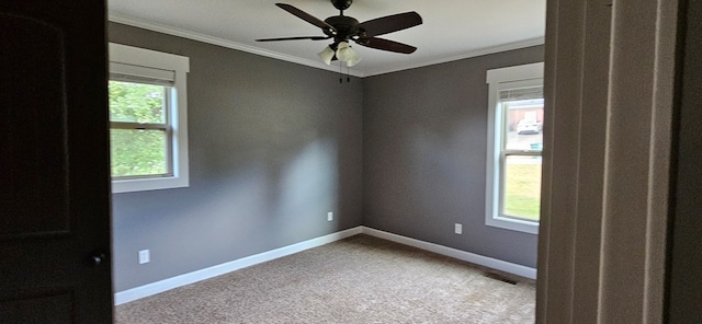 unfurnished room with light colored carpet, a wealth of natural light, ornamental molding, and ceiling fan