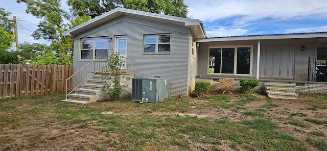 back of house with a yard and central AC unit