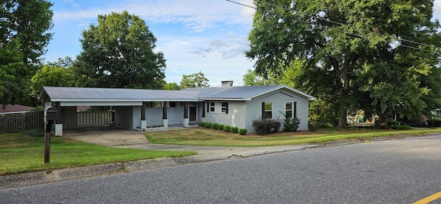 ranch-style home featuring a carport and a front yard