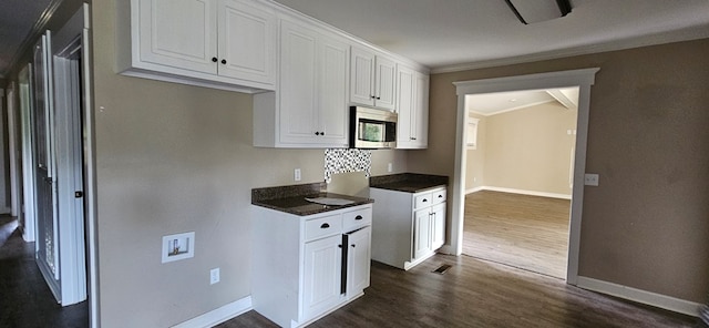 kitchen featuring white cabinetry, ornamental molding, and dark hardwood / wood-style floors