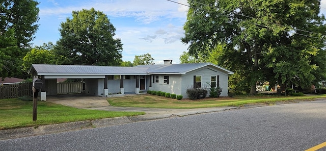 ranch-style home featuring a front lawn and a carport