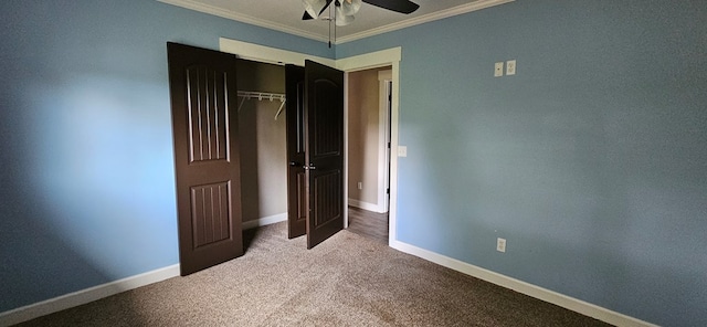 unfurnished bedroom featuring crown molding, carpet floors, ceiling fan, and a closet