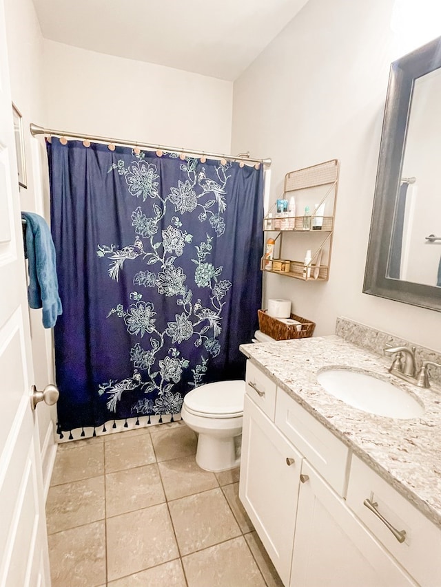 bathroom with toilet, tile patterned flooring, and vanity