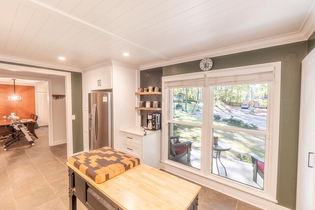 dining space featuring crown molding, wooden ceiling, and light tile patterned flooring