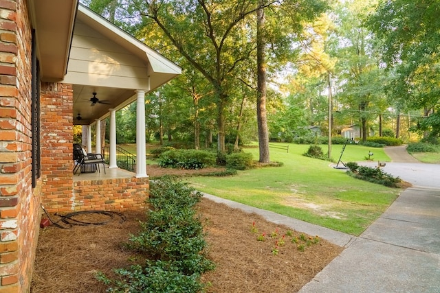 view of yard featuring a porch and ceiling fan