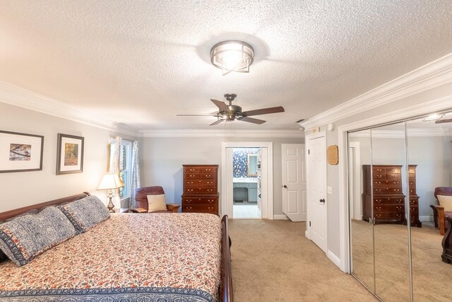 carpeted bedroom featuring a textured ceiling, a closet, ceiling fan, and ornamental molding