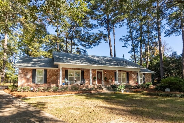 single story home featuring covered porch and a front yard