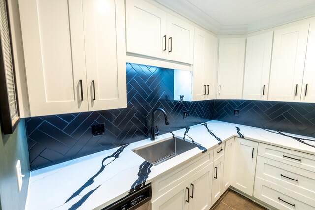 kitchen featuring backsplash, light stone countertops, sink, and white cabinets