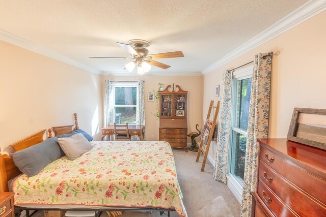 carpeted bedroom with a textured ceiling, ceiling fan, and ornamental molding