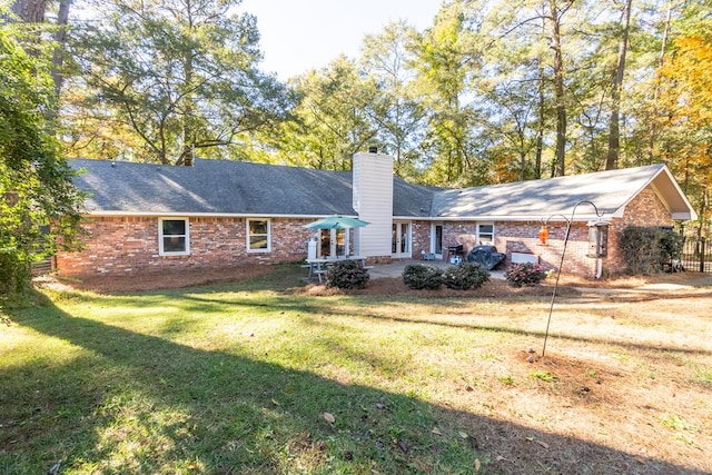 rear view of property featuring a patio area and a yard