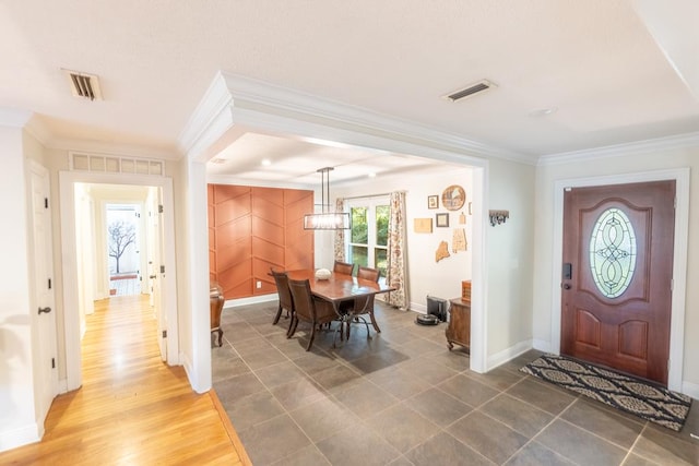 entrance foyer featuring dark hardwood / wood-style flooring, ornamental molding, and a notable chandelier