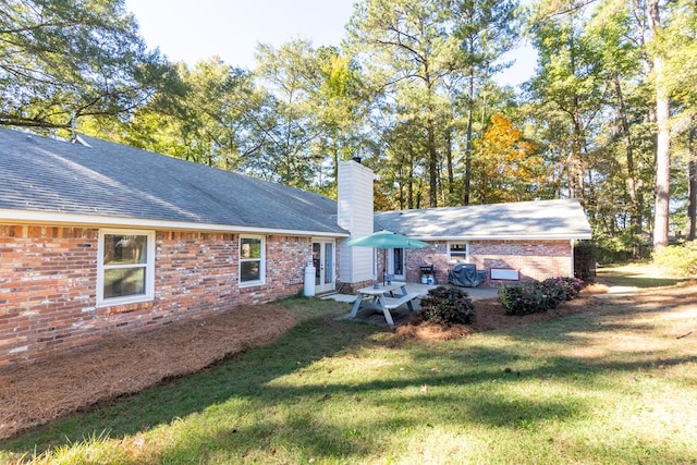 back of property with a patio area and a lawn