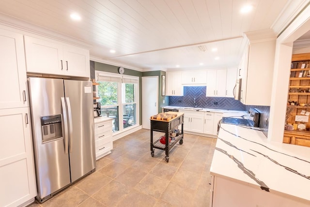 kitchen featuring white cabinets, crown molding, decorative backsplash, appliances with stainless steel finishes, and light tile patterned flooring