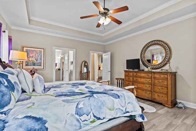 bedroom featuring light hardwood / wood-style flooring, ensuite bathroom, a raised ceiling, ceiling fan, and ornamental molding