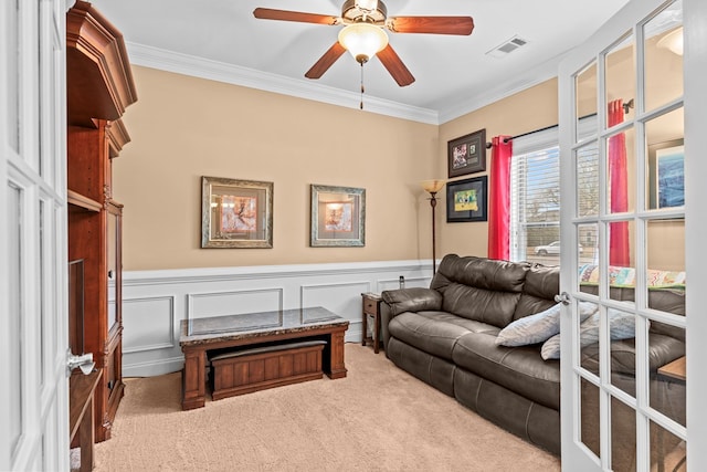 living area featuring ceiling fan, ornamental molding, and carpet