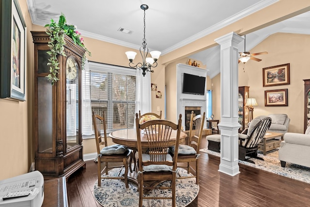 dining space with a fireplace, decorative columns, vaulted ceiling, ceiling fan with notable chandelier, and dark hardwood / wood-style floors