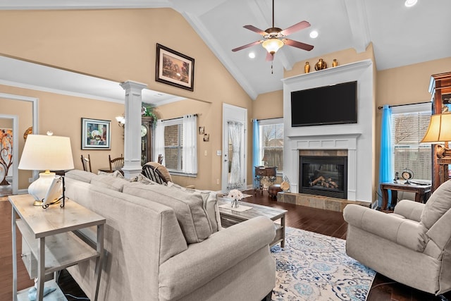 living room with ornate columns, high vaulted ceiling, a tiled fireplace, ceiling fan, and wood-type flooring