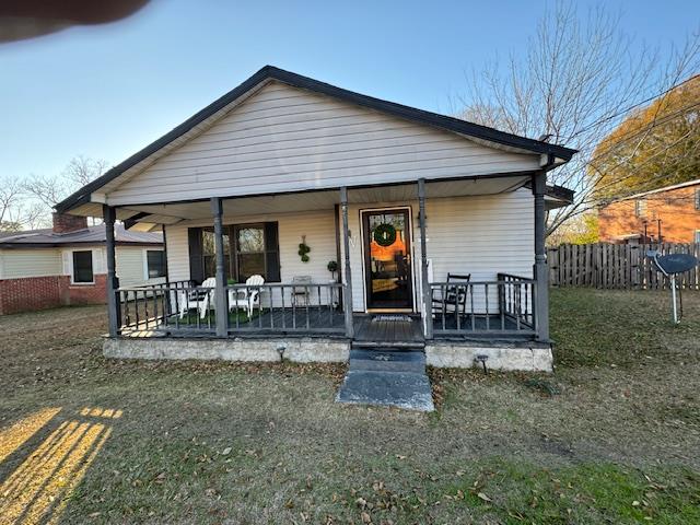 back of house with a porch and a lawn